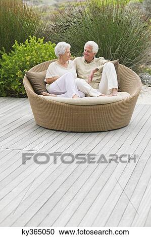 Senior couple sitting in a wicker couch View Large Photo Image Stock Image - Senior couple sitting in a wicker couch. Fotosearch