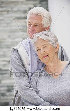 Senior man embracing his wife from behind View Large Photo Image Stock Photography - Senior man embracing his wife from behind. Fotosearch