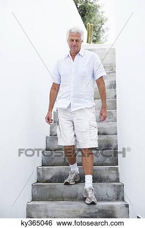 Senior man getting down steps View Large Photo Image Stock Photograph - Senior man getting down steps. Fotosearch