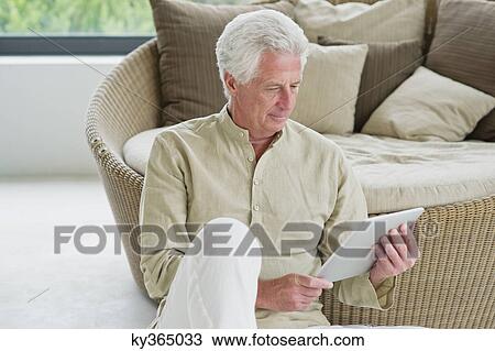 Senior man holding a digital tablet View Large Photo Image Stock Image - Senior man holding a digital tablet. Fotosearch