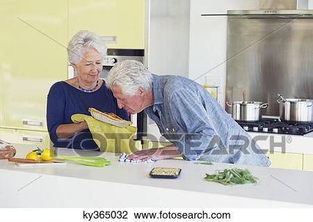 Senior man smelling sweet food while woman holding it View Large Photo Image Stock Image - Senior man smelling sweet food while woman holding it. Fotosearch