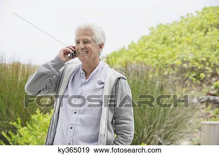 Senior man talking on a mobile phone View Large Photo Image Stock Photo - Senior man talking on a mobile phone. Fotosearch
