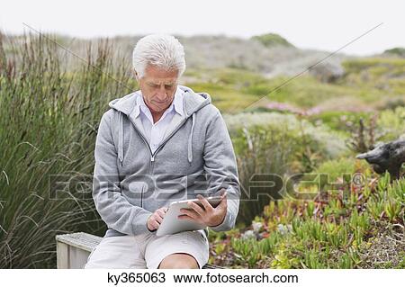 Senior man using a digital tablet View Large Photo Image Stock Image - Senior man using a digital tablet. Fotosearch