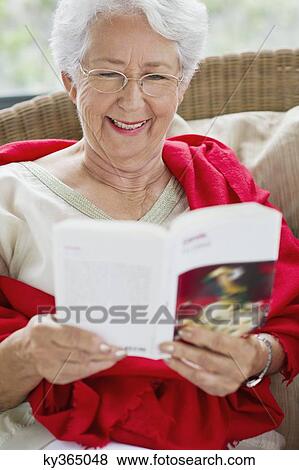 Senior woman reading a magazine and smiling View Large Photo Image Stock Photo - Senior woman reading a magazine and smiling. Fotosearch