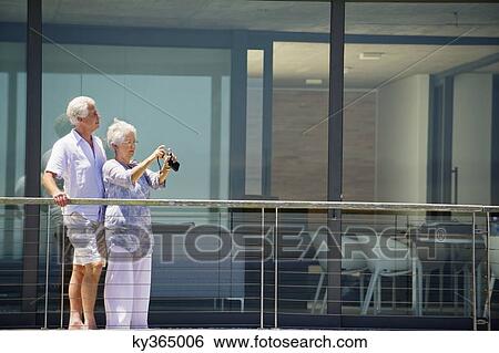 Senior woman taking picture with a digital camera View Large Photo Image Stock Photograph - Senior woman taking picture with a digital camera. Fotosearch