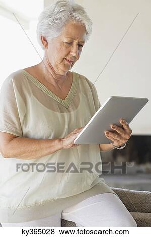 Senior woman using a digital tablet View Large Photo Image Stock Photo - Senior woman using a digital tablet. Fotosearch