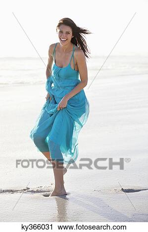 Stock Image - Beautiful laughing woman enjoying at beach. Fotosearch