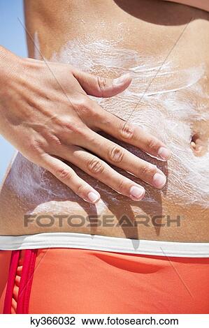 Close-up of a woman applying suntan lotion on her body View Large Photo Image Stock Image - Close-up of a woman applying suntan lotion on her body. Fotosearch