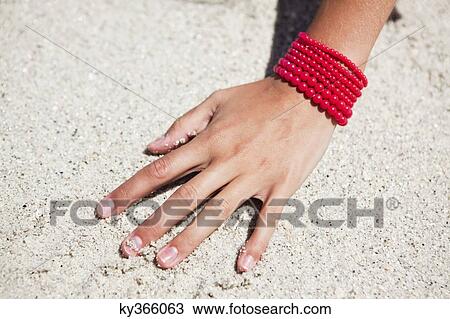 Close-up of a woman's hand on sand View Large Photo Image Stock Image - Close-up of a woman's hand on sand. Fotosearch