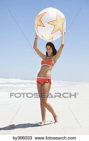 Stock Image - Woman playing with beach ball. Fotosearch