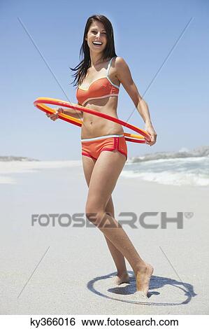Woman playing with plastic hoops on the beach View Large Photo Image Stock Photograph - Woman playing with plastic hoops on the beach. Fotosearch