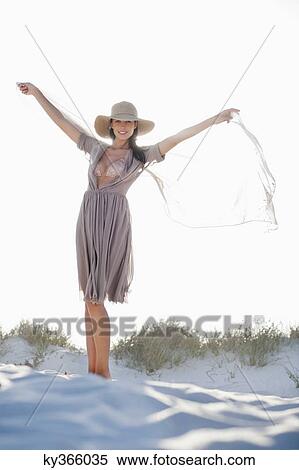 Woman standing on the beach with arm outstretched View Large Photo Image Stock Photography - Woman standing on the beach with arm outstretched. Fotosearch