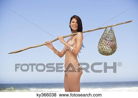 Young woman carrying net bag on shoulder View Large Photo Image Stock Photo - Young woman carrying net bag on shoulder. Fotosearch