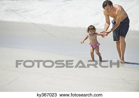 Father walking with little girl on the beach View Large Photo Image Stock Image - Father walking with little girl on the beach. Fotosearch