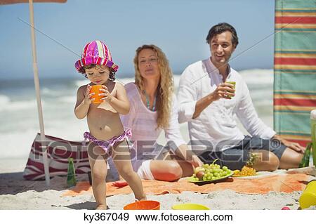 Stock Photo - Girl drinking juice on the beach. Fotosearch