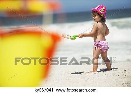 Side profile of a girl digging with a sand shovel on the beach View Large Photo Image Stock Image - Side profile of a girl digging with a sand shovel on the beach. Fotosearch