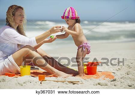 Woman and her daughter playing with pail and shovel on the beach View Large Photo Image Stock Image - Woman and her daughter playing with pail and shovel on the beach. Fotosearch