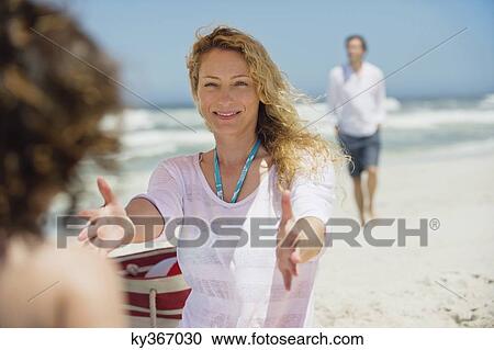 Woman playing with her daughter on the beach View Large Photo Image Stock Image - Woman playing with her daughter on the beach. Fotosearch