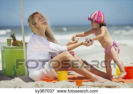 Stock Photo - Woman playing with her daughter on the beach. Fotosearch