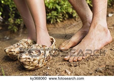 Low section view of a woman wearing wicker shoe with a barefooted man View Large Photo Image Stock Image - Low section view of a woman wearing wicker shoe with a barefooted man. Fotosearch