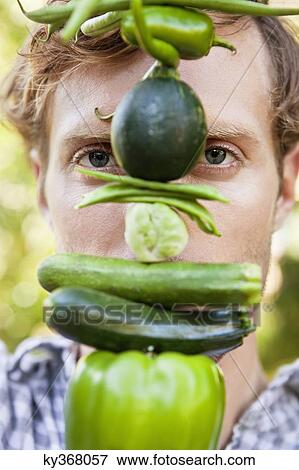 Stock Photo - Portrait of a man holding vegetables. Fotosearch