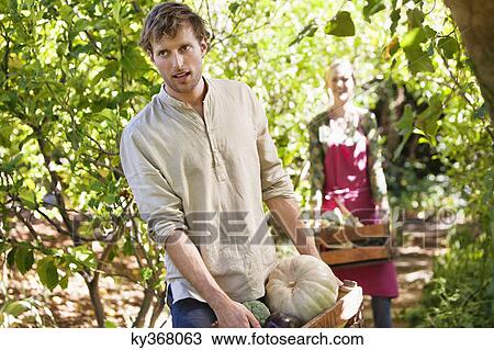 Smiling man holding a crate of vegetables View Large Photo Image Stock Image - Smiling man holding a crate of vegetables. Fotosearch
