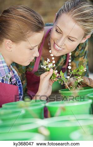 Stock Photo - Smiling mother and daughter gardening. Fotosearch