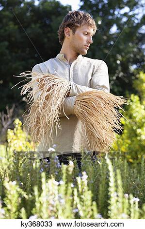 Young man standing in a field as scarecrow View Large Photo Image Stock Image - Young man standing in a field as scarecrow. Fotosearch