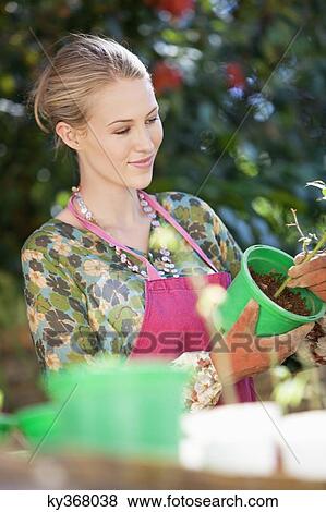 Stock Photo - Young woman gardening and smiling. Fotosearch