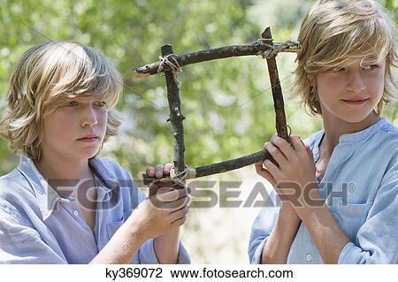 Children holding frame of driftwood and looking away outdoors View Large Photo Image Stock Image - Children holding frame of driftwood and looking away outdoors. Fotosearch