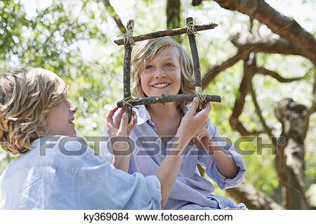 Children making frame of driftwood outdoors View Large Photo Image Picture - Children making frame of driftwood outdoors. Fotosearch
