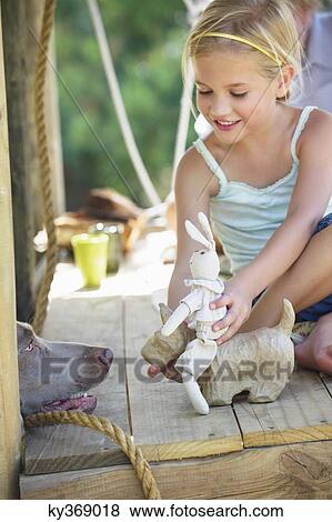 Girl playing with toys in tree house View Large Photo Image Stock Photo - Girl playing with toys in tree house. Fotosearch