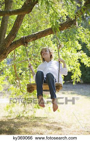 Happy little boy swinging on tree View Large Photo Image Stock Photograph - Happy little boy swinging on tree. Fotosearch