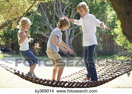 Little siblings standing in hammock View Large Photo Image Picture - Little siblings standing in hammock. Fotosearch