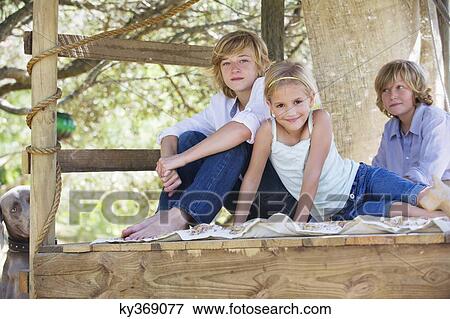Portrait of children sitting in tree house View Large Photo Image Stock Photo - Portrait of children sitting in tree house. Fotosearch