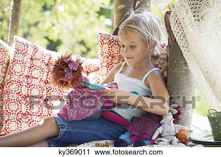 Smiling little girl holding toys in tree house View Large Photo Image Stock Image - Smiling little girl holding toys in tree house. Fotosearch
