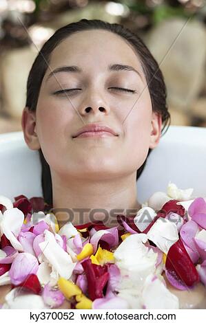 Beautiful young woman relaxing in bathtub with petals View Large Photo Image Stock Image - Beautiful young woman relaxing in bathtub with petals. Fotosearch