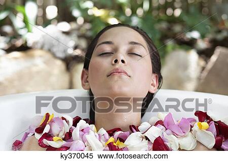 Beautiful young woman relaxing in bathtub with petals View Large Photo Image Stock Photography - Beautiful young woman relaxing in bathtub with petals. Fotosearch