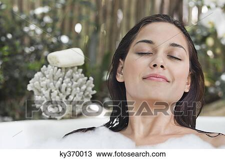 Beautiful young woman taking bubble bath with her eyes closed View Large Photo Image Stock Image - Beautiful young woman taking bubble bath with her eyes closed. Fotosearch