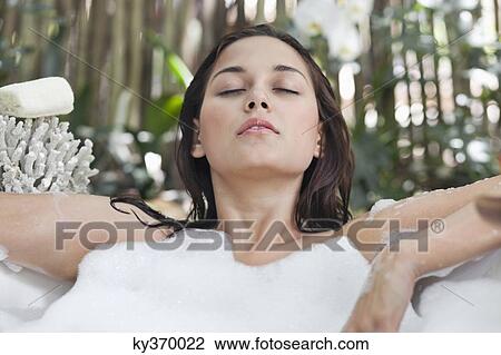 Beautiful young woman taking bubble bath with her eyes closed View Large Photo Image Stock Image - Beautiful young woman taking bubble bath with her eyes closed. Fotosearch
