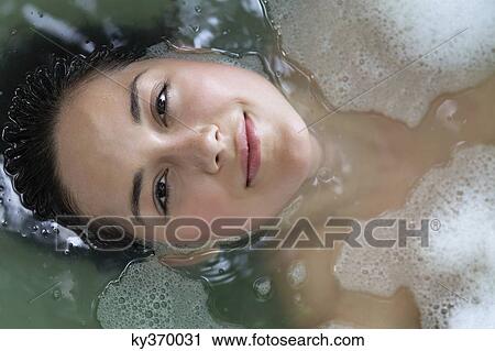Portrait of a beautiful young woman relaxing in a bathtub View Large Photo Image Stock Image - Portrait of a beautiful young woman relaxing in a bathtub. Fotosearch