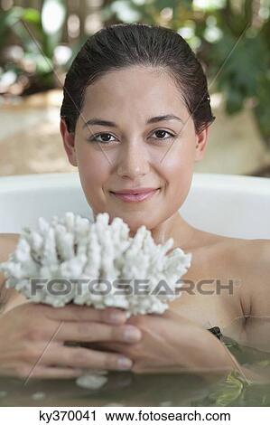 Portrait of a beautiful young woman holding bath sponge in a bathtub View Large Photo Image Stock Image - Portrait of a beautiful young woman holding bath sponge in a bathtub. Fotosearch