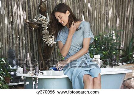Young woman pouring aromatherapy oil in bathtub View Large Photo Image Stock Photograph - Young woman pouring aromatherapy oil in bathtub. Fotosearch