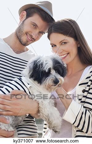 Couple carrying a puppy, Paris, Ile-de-France, France View Large Photo Image Stock Photo - Couple carrying a puppy, Paris, Ile-de-France, France. Fotosearch