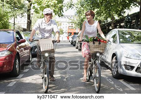 Couple carrying vegetables on bicycles, Paris, Ile-de-France, France View Large Photo Image Stock Photo - Couple carrying vegetables on bicycles, Paris, Ile-de-France, France. Fotosearch