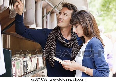 Couple choosing books at a book stall, Paris, Ile-de-France, France View Large Photo Image Stock Photo - Couple choosing books at a book stall, Paris, Ile-de-France, France. Fotosearch