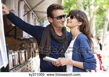 Stock Photography - Couple choosing books at a book stall, Paris, Ile-de-France, France. Fotosearch