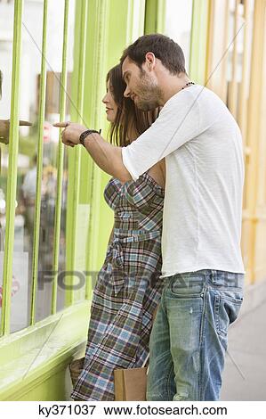 Couple looking at the display window of a store, Paris, Ile-de-France, France View Large Photo Image Stock Photo - Couple looking at the display window of a store, Paris, Ile-de-France, France. Fotosearch