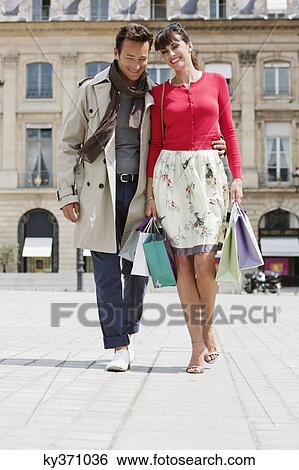 Stock Photograph - Couple walking on a street, Paris, Ile-de-France, France. Fotosearch