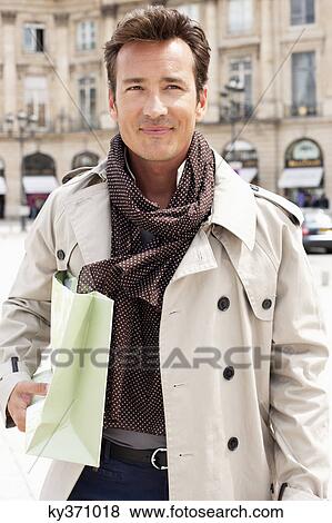 Stock Photo - Man holding a shopping bag, Paris, Ile-de-France, France. Fotosearch
